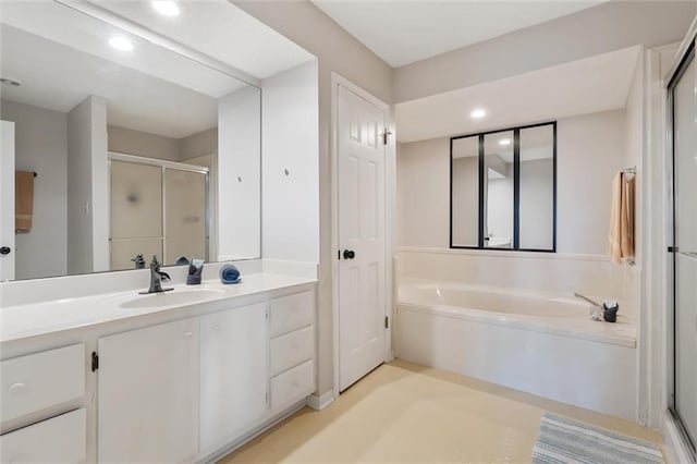 full bathroom featuring recessed lighting, a shower stall, vanity, and a bath