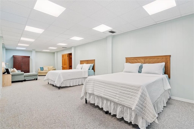 bedroom with carpet, visible vents, and a paneled ceiling