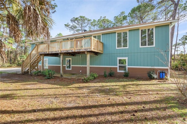 back of property with stairway, a deck, and a yard