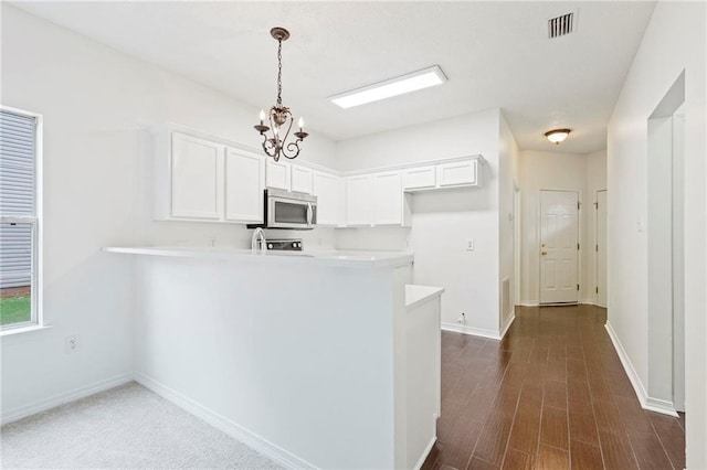 kitchen with white cabinetry, kitchen peninsula, and pendant lighting