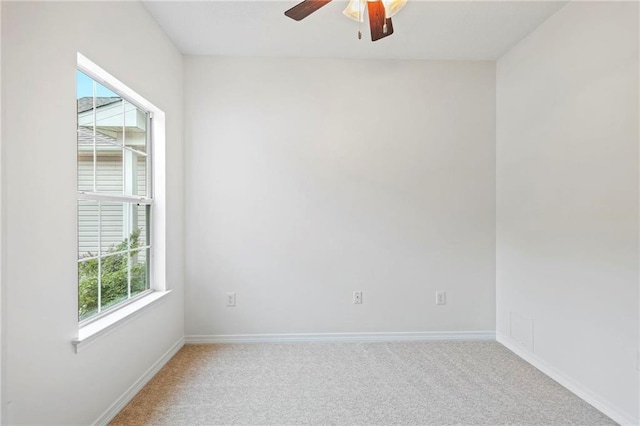 unfurnished room with plenty of natural light, light carpet, and ceiling fan