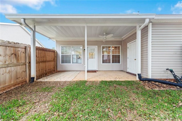 back of property with ceiling fan, a lawn, and a patio area