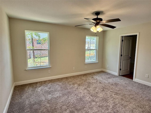 carpeted empty room with baseboards, a wealth of natural light, and ceiling fan