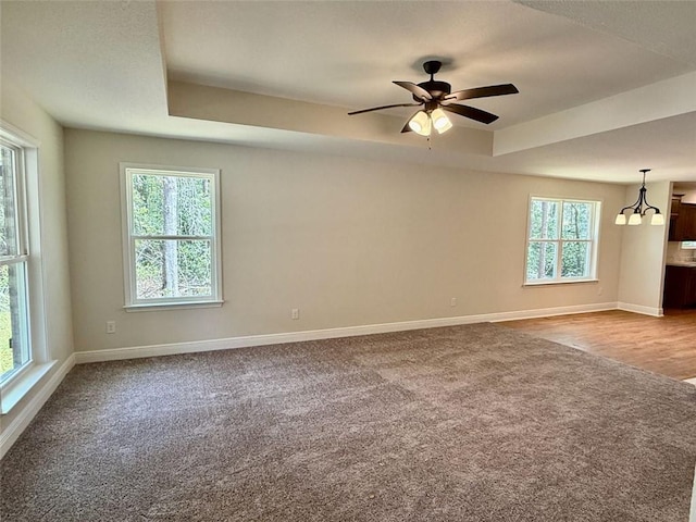 unfurnished room with baseboards, a wealth of natural light, and carpet floors