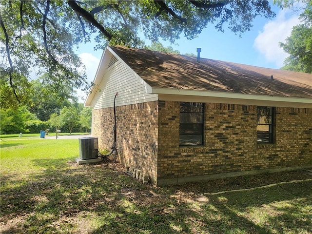 6290 Quail Ct, Theodore, AL 36582 - view of side of home with central AC unit, a lawn, brick siding, and a shingled roof