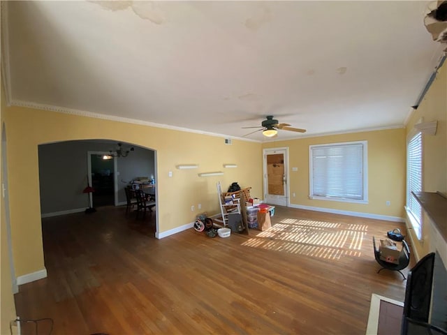 unfurnished living room featuring dark wood-type flooring, ceiling fan, and crown molding