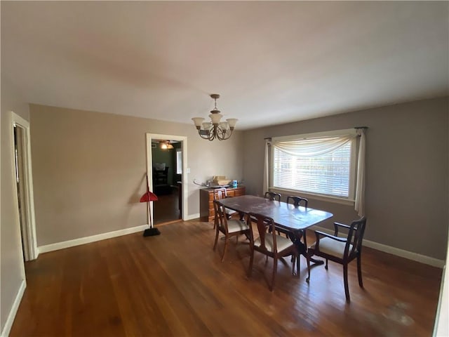 dining space featuring an inviting chandelier and dark hardwood / wood-style flooring