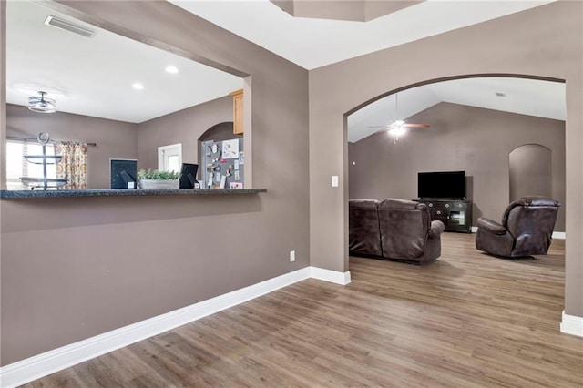 interior space with visible vents, baseboards, wood finished floors, and a ceiling fan