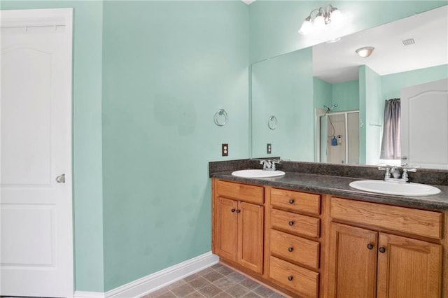 full bathroom with double vanity, visible vents, a shower with shower door, and a sink