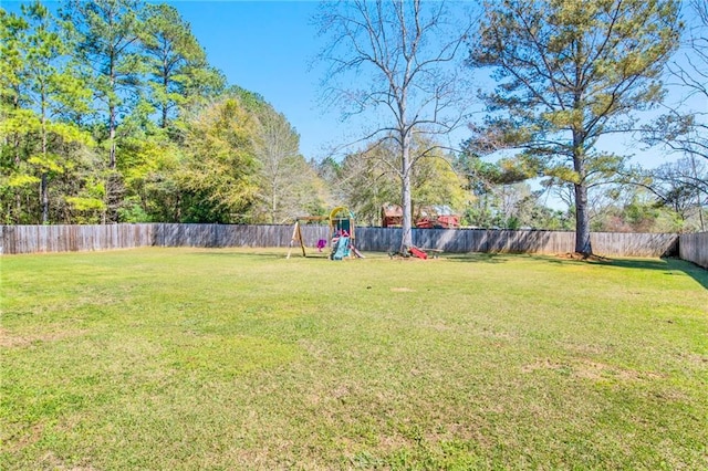 view of yard with a playground and a fenced backyard