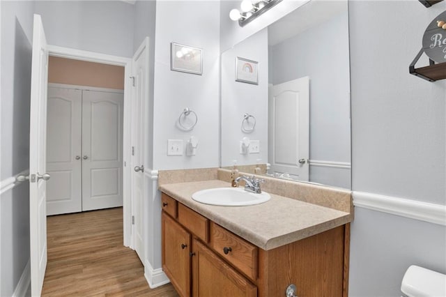 bathroom featuring vanity, toilet, and wood finished floors