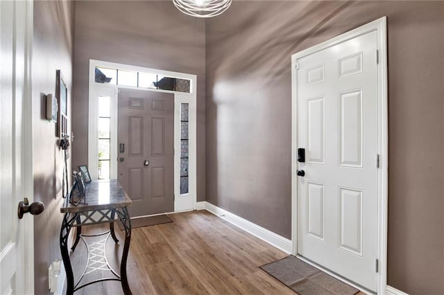 foyer entrance with baseboards and wood finished floors