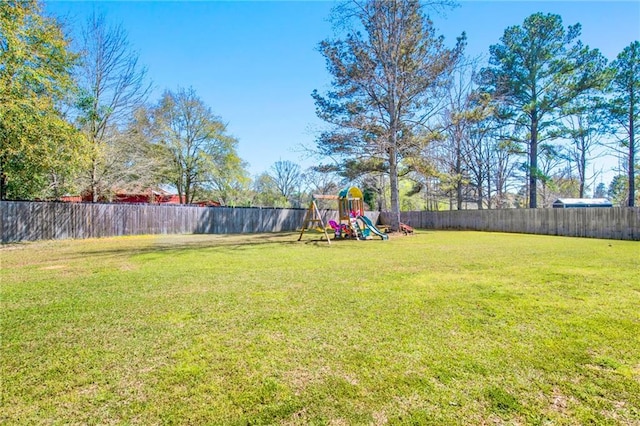 view of yard with a playground and a fenced backyard