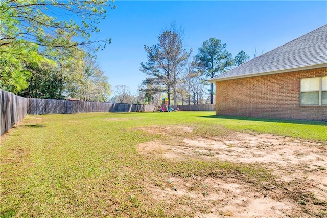 view of yard featuring a fenced backyard and a playground