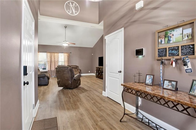 interior space with wood finished floors, baseboards, and high vaulted ceiling