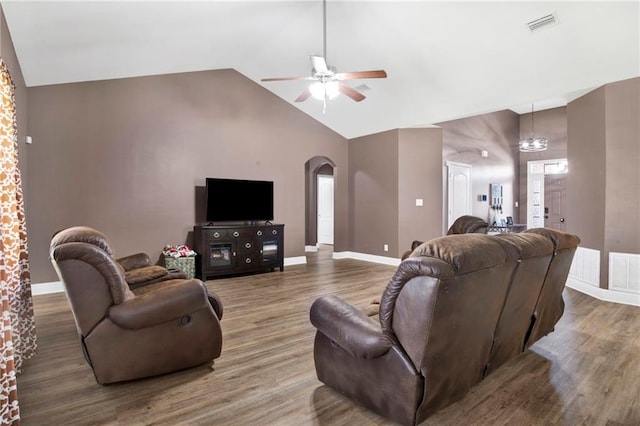 living area featuring wood finished floors, baseboards, a ceiling fan, visible vents, and arched walkways