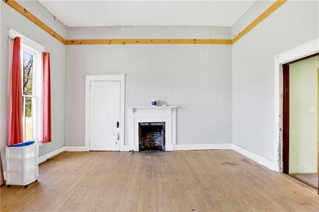 52780 State Highway 59, Stockton, AL 36579 - unfurnished living room featuring a fireplace with flush hearth, hardwood / wood-style flooring, and baseboards