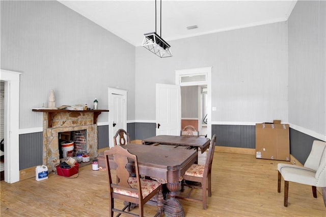 52780 State Highway 59, Stockton, AL 36579 - dining space featuring wood finished floors, a stone fireplace, ornamental molding, and a towering ceiling