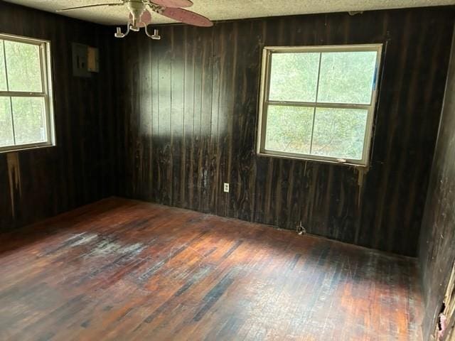 15131 Moffett Rd, Wilmer, AL 36587 - empty room with wooden walls, hardwood / wood-style flooring, and ceiling fan