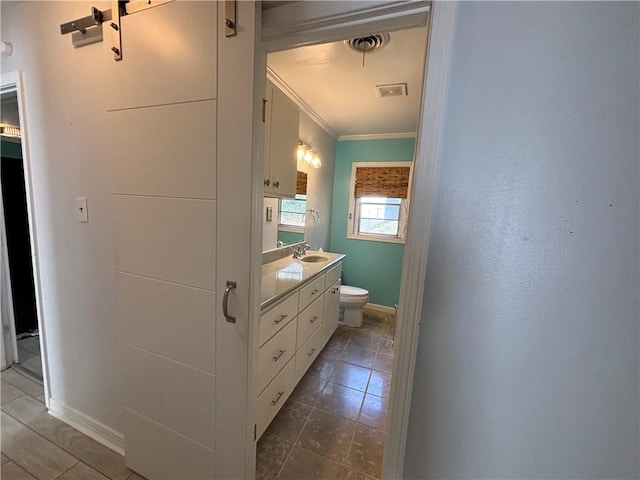 bathroom featuring vanity, toilet, and crown molding