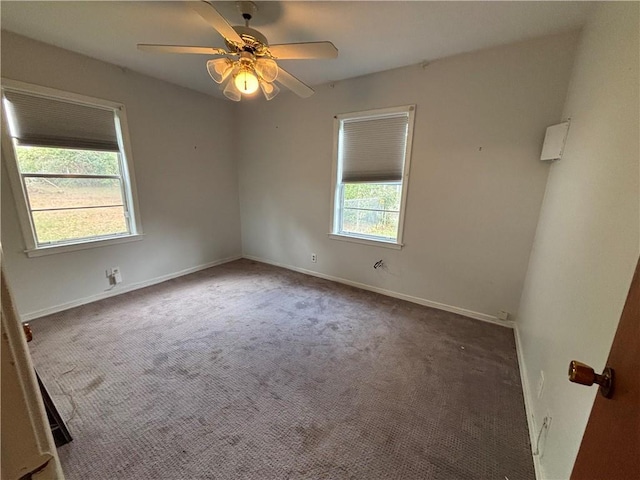 carpeted spare room featuring ceiling fan