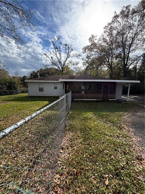 back of property with a sunroom and a yard