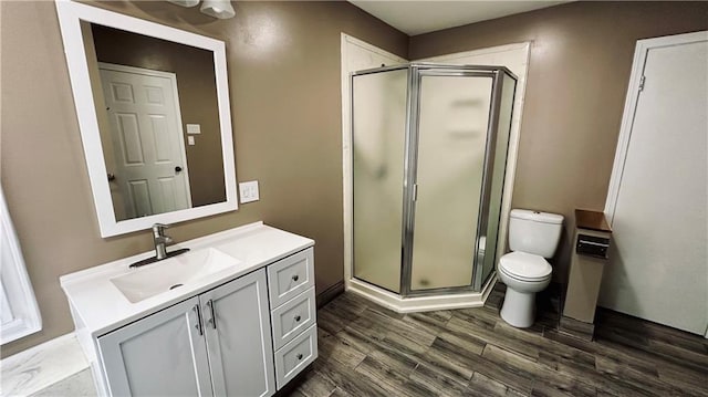 bathroom with an enclosed shower, toilet, vanity, and hardwood / wood-style floors