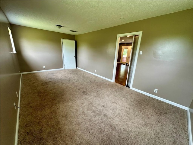 carpeted spare room with a textured ceiling