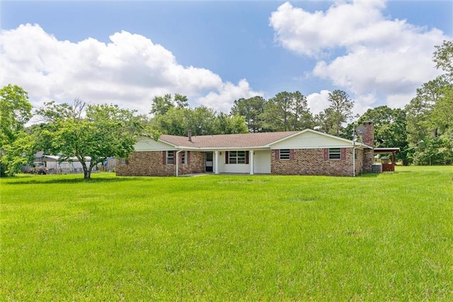 rear view of property featuring a lawn