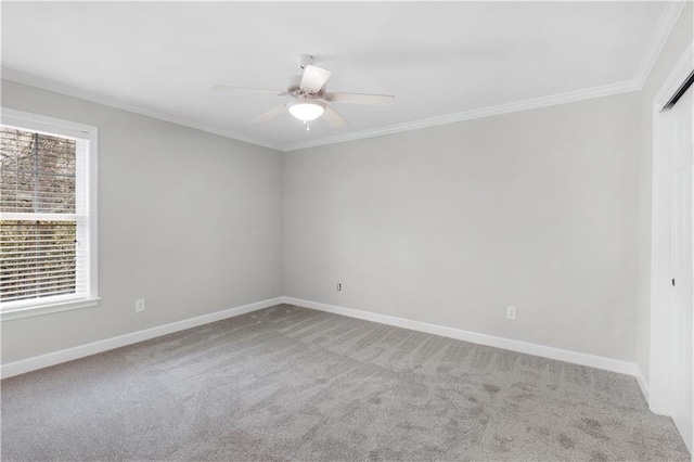 carpeted spare room featuring baseboards, ceiling fan, and crown molding