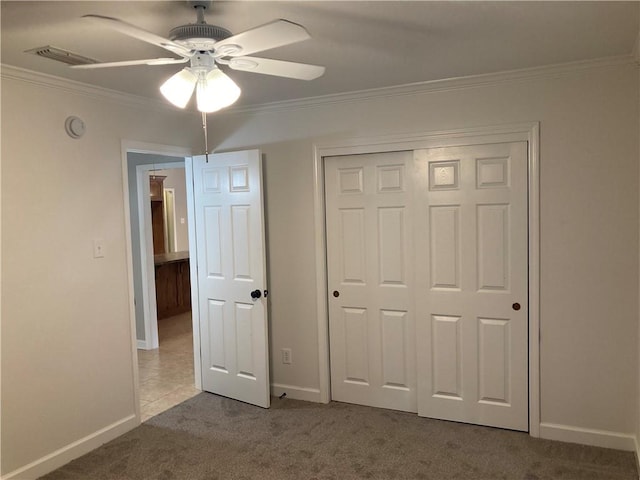 unfurnished bedroom with light carpet, visible vents, baseboards, a closet, and crown molding