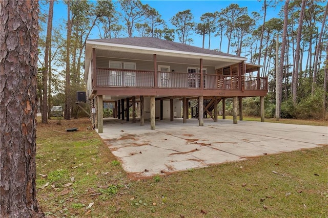 view of front of home with a front yard, a porch, a carport, and concrete driveway