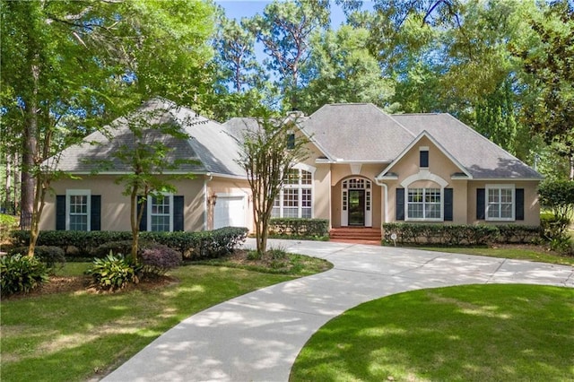 104 Ferncliff Cir, Daphne, AL 36526 - view of front of home with curved driveway, stucco siding, a front lawn, and an attached garage