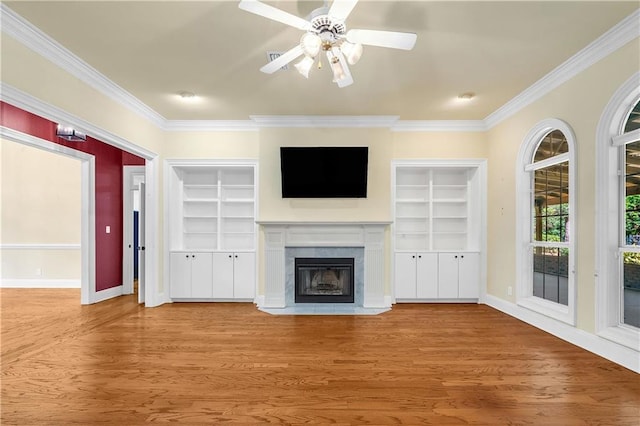 104 Ferncliff Cir, Daphne, AL 36526 - unfurnished living room featuring crown molding, a ceiling fan, a fireplace, wood finished floors, and built in features