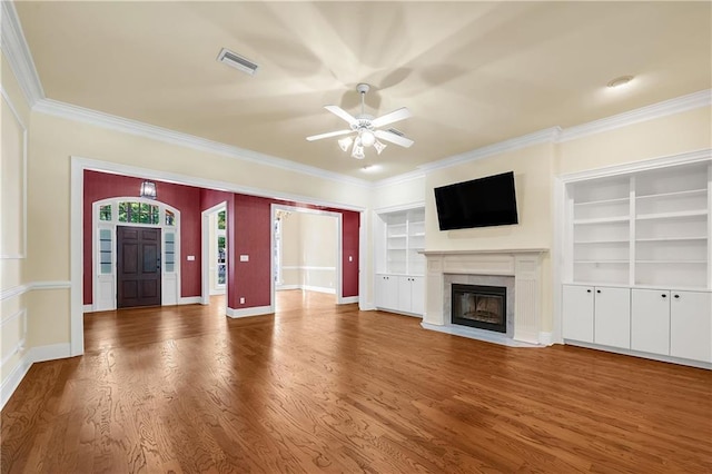 104 Ferncliff Cir, Daphne, AL 36526 - unfurnished living room with ornamental molding, a ceiling fan, wood finished floors, a fireplace with flush hearth, and built in shelves