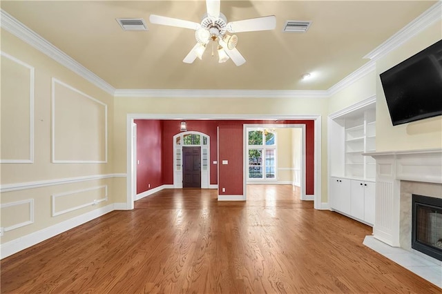 104 Ferncliff Cir, Daphne, AL 36526 - unfurnished living room featuring ceiling fan, crown molding, a tiled fireplace, wood finished floors, and baseboards