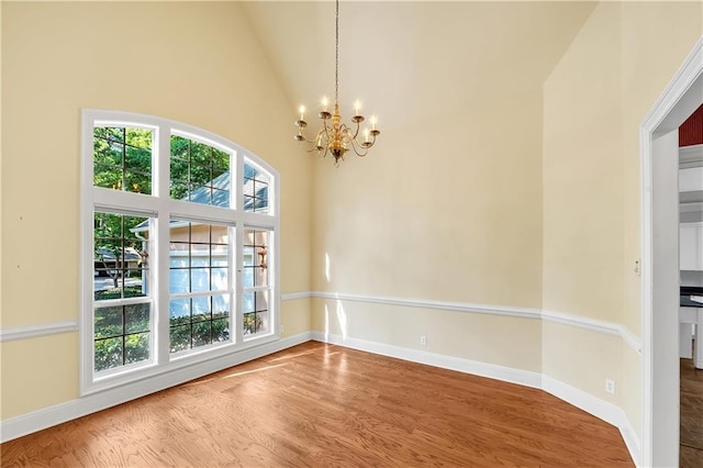 104 Ferncliff Cir, Daphne, AL 36526 - unfurnished dining area with a chandelier, wood finished floors, baseboards, and high vaulted ceiling