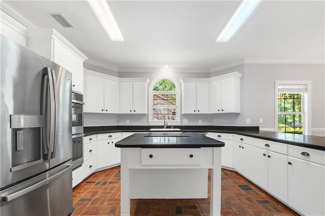 104 Ferncliff Cir, Daphne, AL 36526 - kitchen featuring appliances with stainless steel finishes, a sink, brick flooring, dark countertops, and healthy amount of natural light