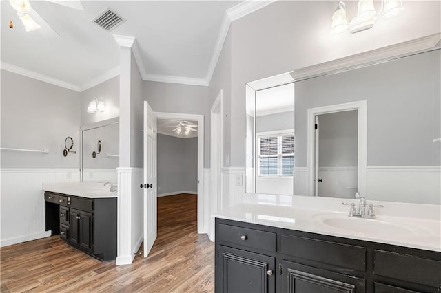 104 Ferncliff Cir, Daphne, AL 36526 - bathroom with ceiling fan, ornamental molding, two vanities, wainscoting, and wood finished floors