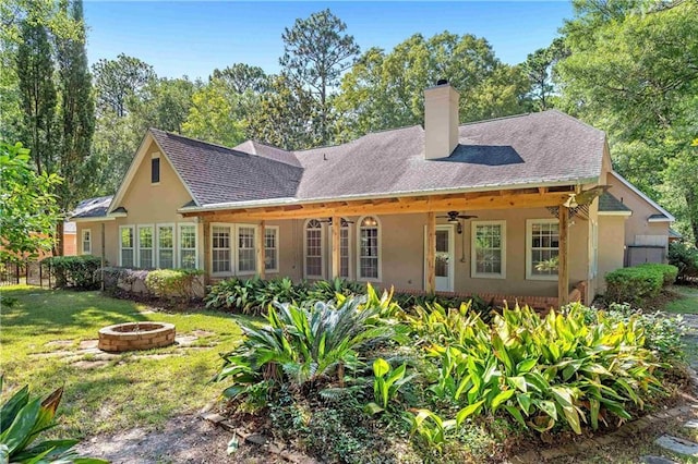 104 Ferncliff Cir, Daphne, AL 36526 - back of property featuring a fire pit, a ceiling fan, a chimney, a lawn, and stucco siding