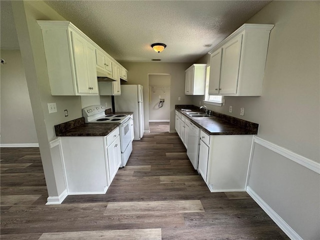 7684 Broome Ct, Theodore, AL 36582 - kitchen with white appliances, dark countertops, a textured ceiling, dark wood-type flooring, and white cabinets