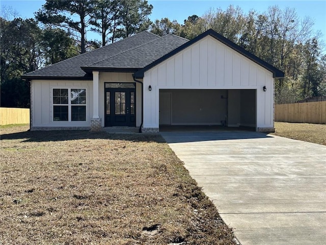 modern farmhouse style home featuring an attached garage, driveway, fence, and board and batten siding