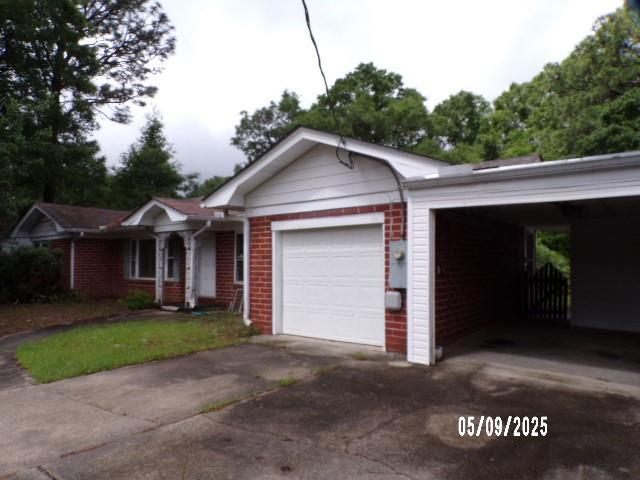 single story home featuring brick siding, a garage, and asphalt driveway