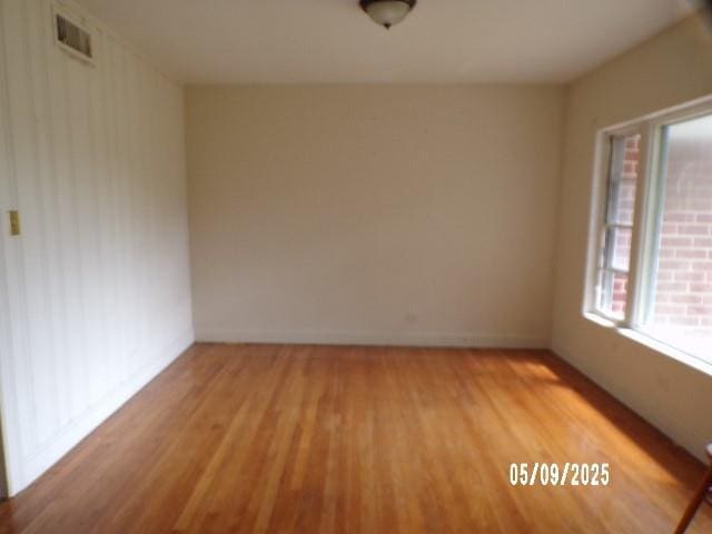 spare room featuring light wood-style floors and baseboards