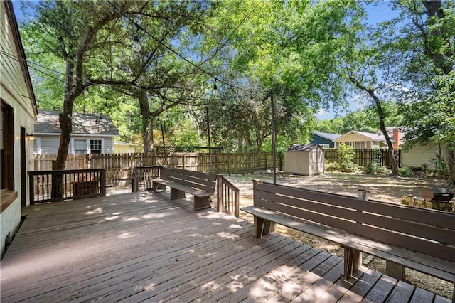 wooden deck with a fenced backyard, an outdoor structure, and a storage shed