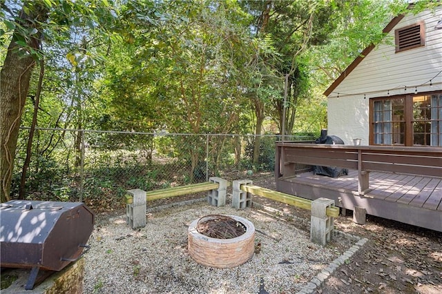 exterior space featuring a fire pit, fence, and a deck