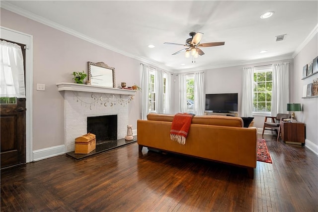 living area featuring visible vents, crown molding, baseboards, a fireplace, and ceiling fan