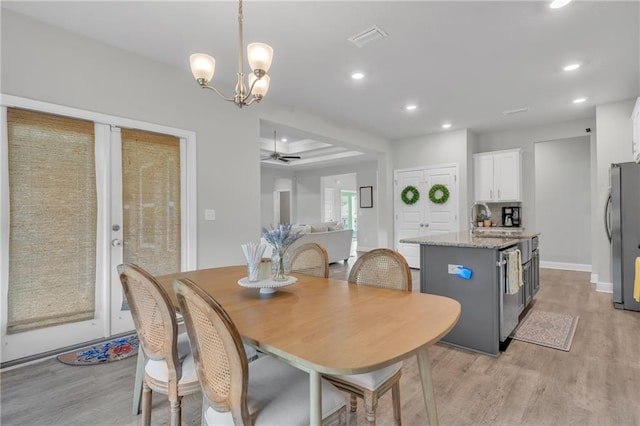 dining space with recessed lighting, baseboards, visible vents, ceiling fan with notable chandelier, and light wood-style floors