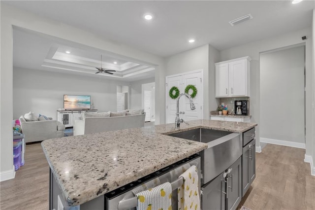 kitchen with baseboards, light wood finished floors, white cabinetry, and dishwasher