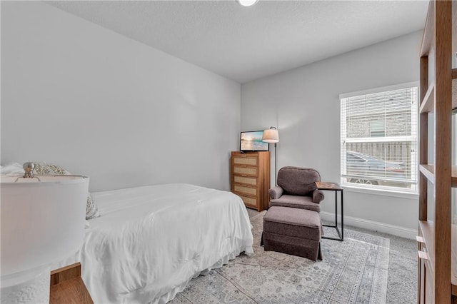 bedroom featuring baseboards, carpet, and a textured ceiling